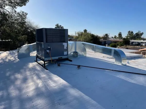Package unit and new ductwork on a flat white roof